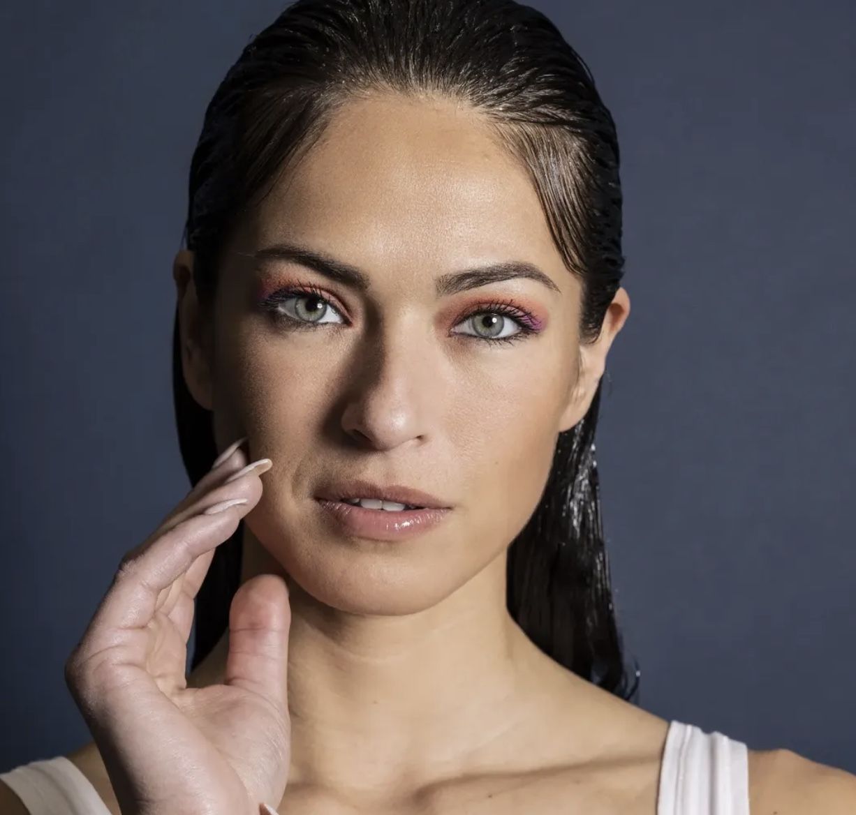 Close-up portret van een model tegen een donkerblauwe achtergrond