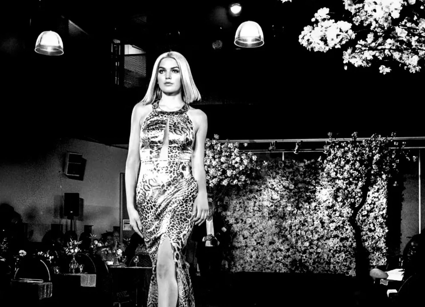 Model op de catwalk in een jurk met luipaardprint, in zwart-wit