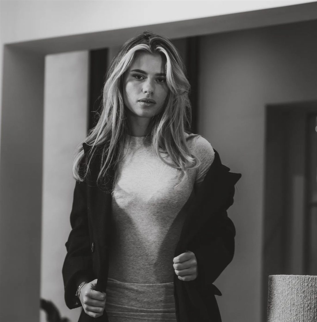 Zwart-witportret van een model in een zwarte jas